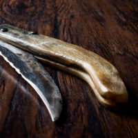 Handmade Wooden Pocket Knife on Dark Surface.