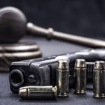 An image of a gun with a gavel An image of a gun with a gavel