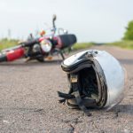 Photo of helmet and motorcycle on road, the concept of road accidents