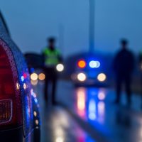 Road accident or traffic stop scene at night focusing on the illuminated rear tail light of a stopped vehicle. Road accident or traffic stop scene at night focusing on the illuminated rear tail light of a stopped vehicle.